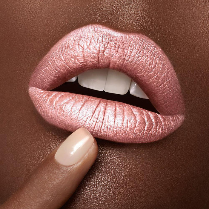 Close-up of a woman's lips with a dark skin tone wearing Runway Rogue's Silk Glam liquid lipstick in shade 'Trophy Wife', a frosted pale pink liquid lipstick with a pearlescent shimmer finish.